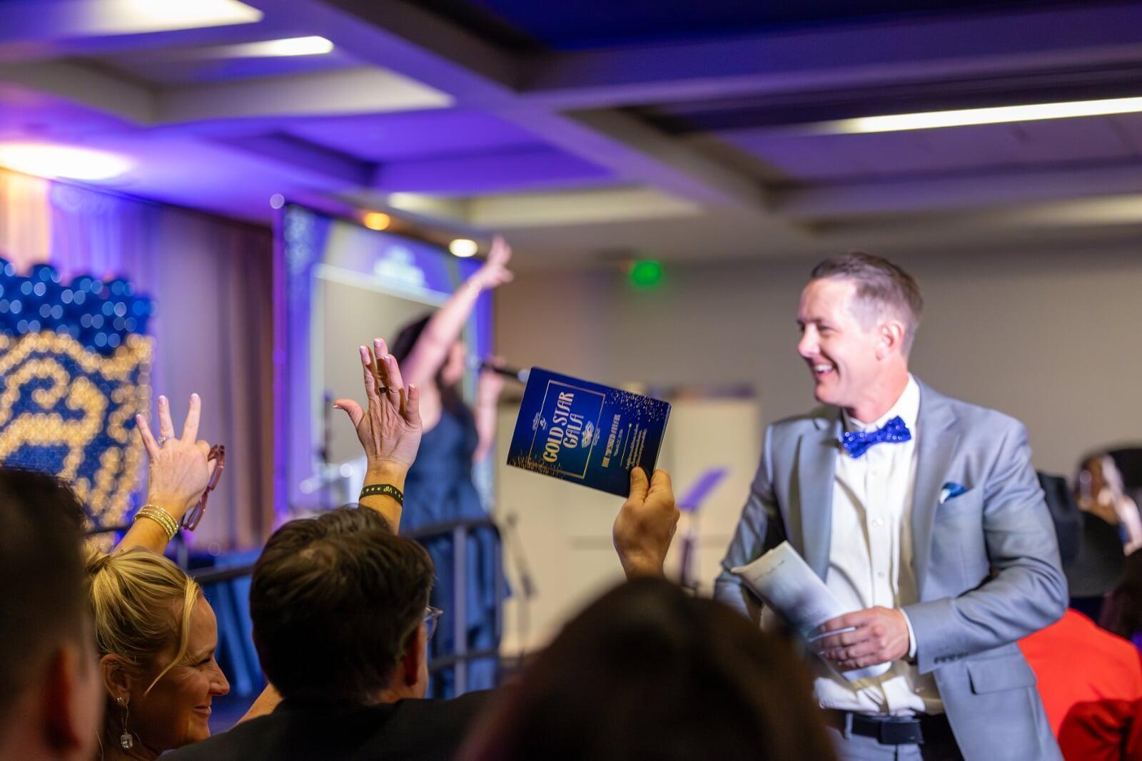 Gala attendees raising bid paddles during a live auction