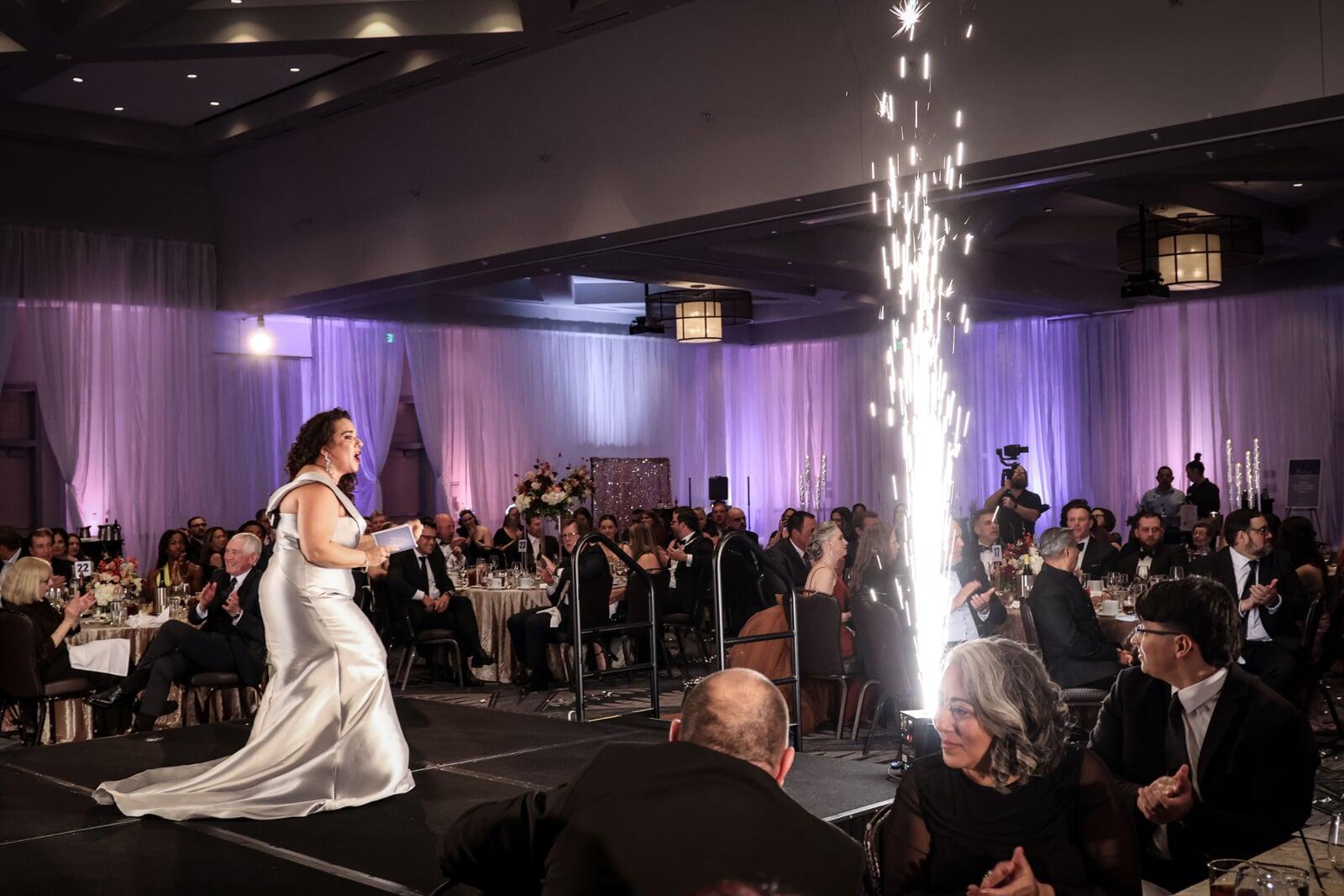 Guests seated at a gala dinner with sparkler display during a fundraising event